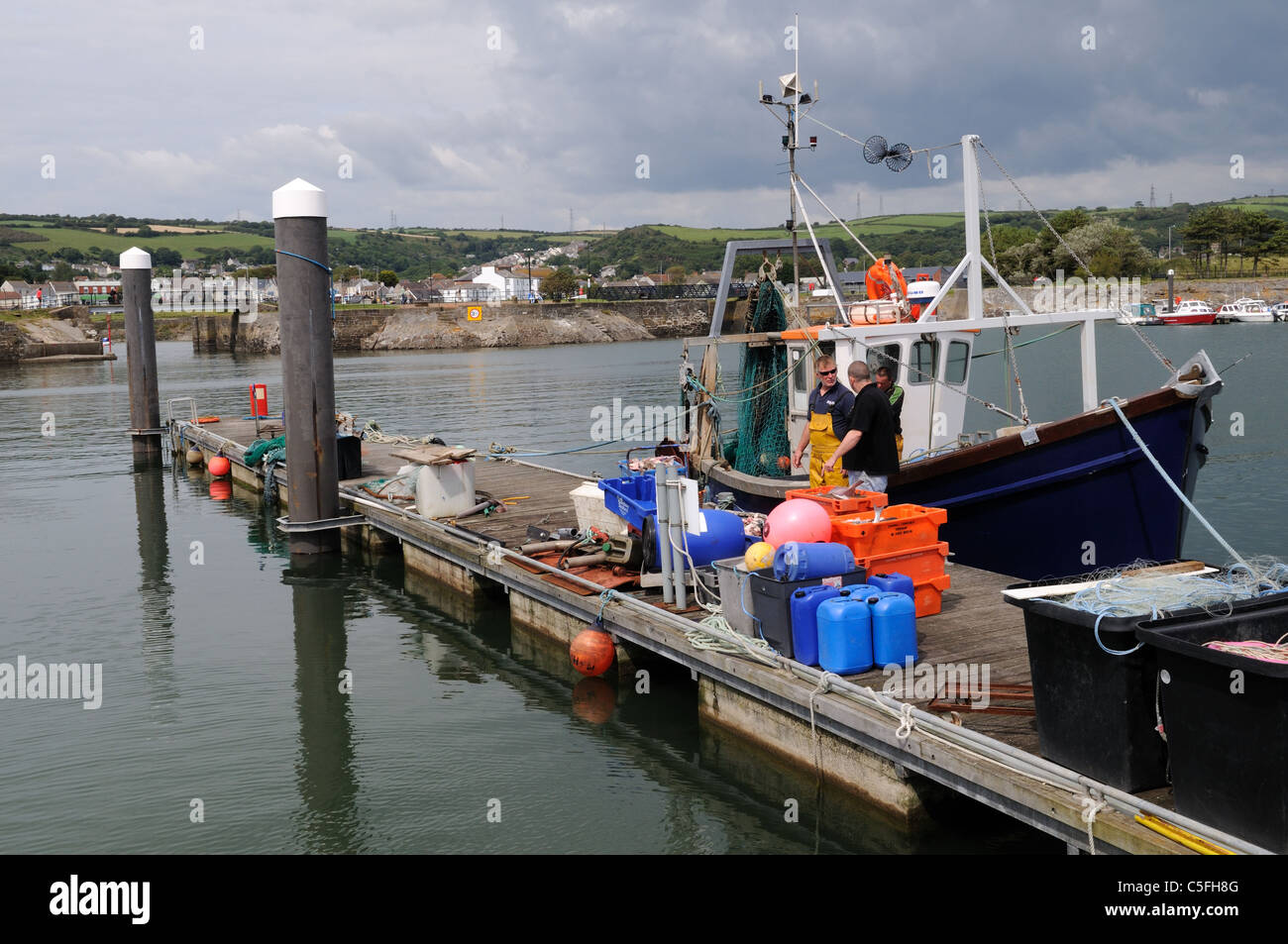 Fishermen landing fish from a fishing boat Burry Port harbour
