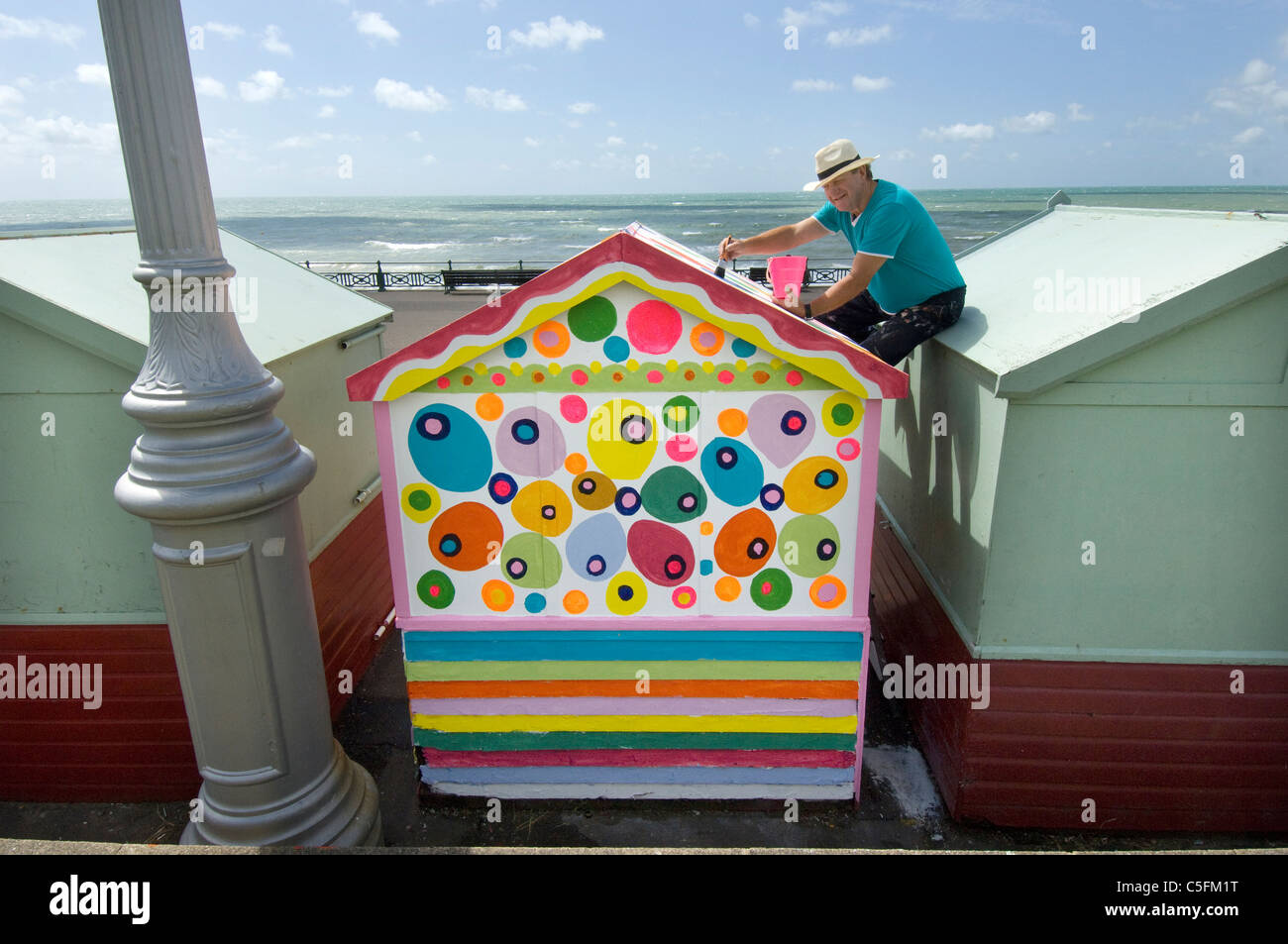 Man painting his beach hut in non-regulation colours Stock Photo