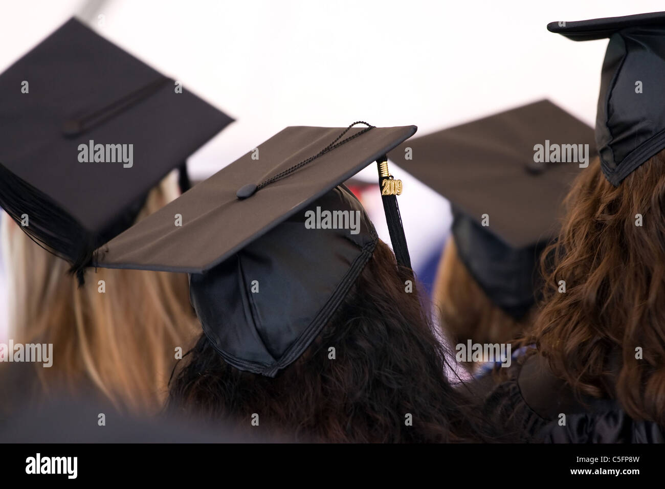 College friends wearing cap and gown hi-res stock photography and ...