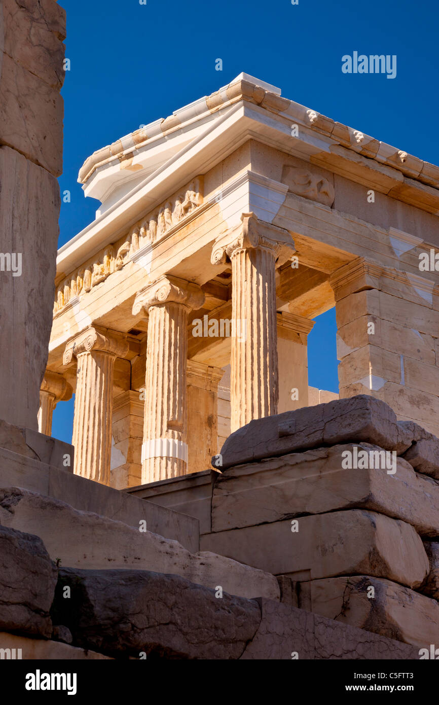 Stone ruins and the Temple of Athena (Apteros) Nike on the Acropolis, Athens Greece Stock Photo