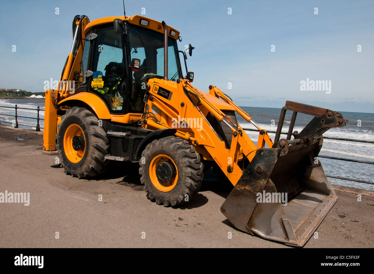 Side view of a JCB digger on the seafront (North Bay) at Scarborough. Stock Photo