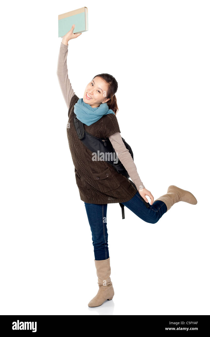 Playful young female student holding a book over her head, white ...