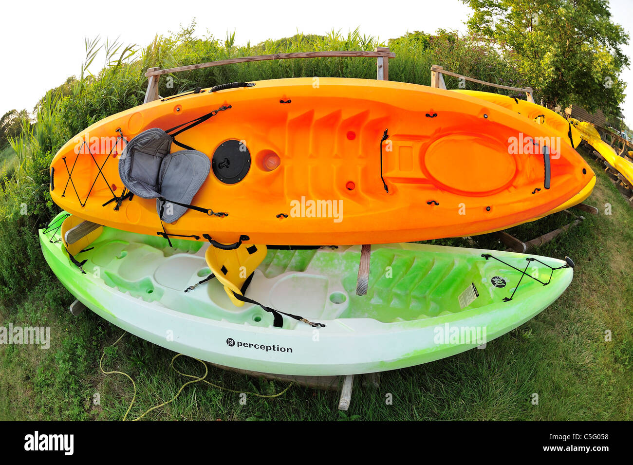 Kayaks, two on racks, for marshland waterway in Long Island, New York, at Norman Levy Park and Preserve (180 degree fisheye) Stock Photo