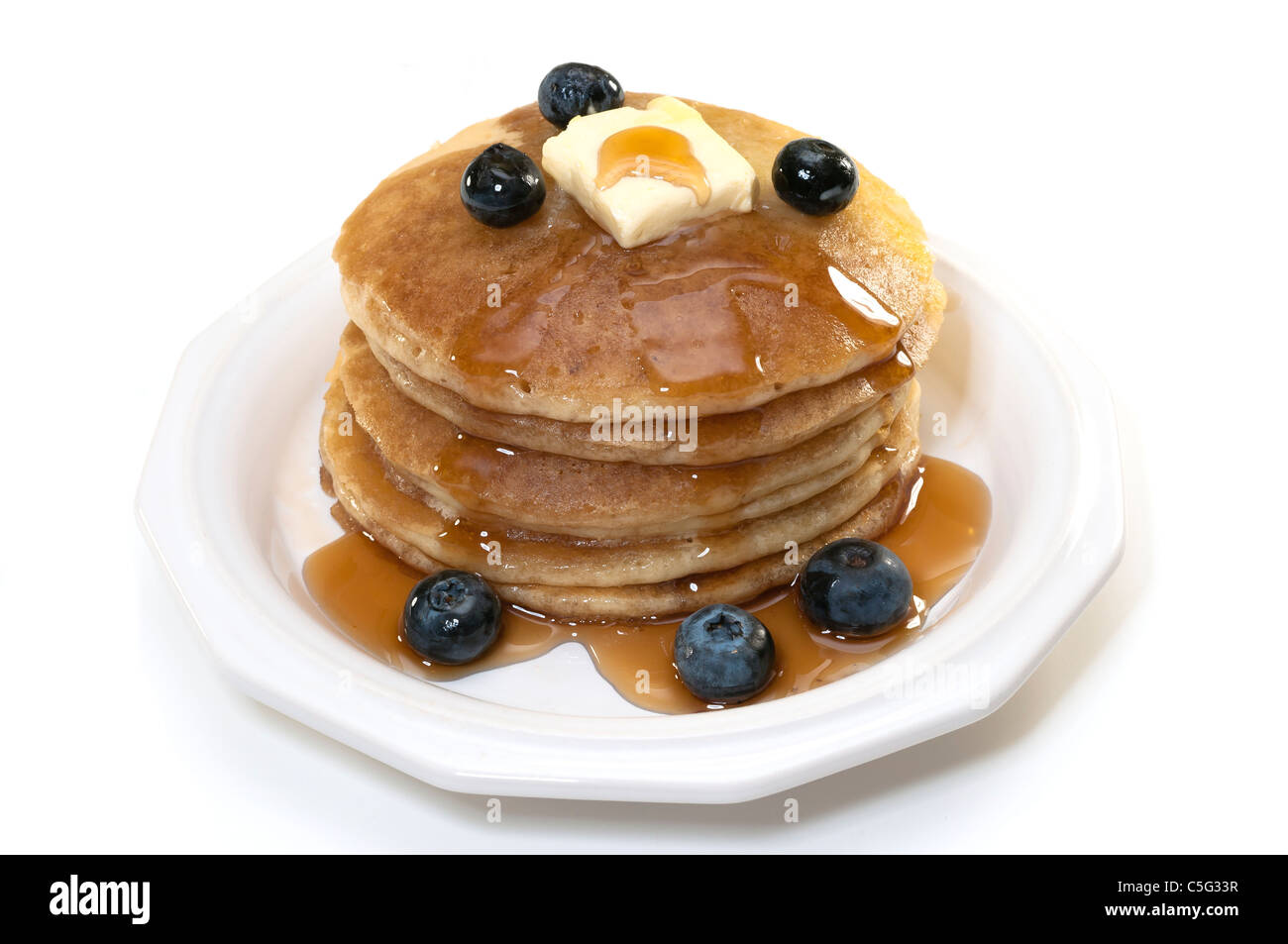 Pancakes with blueberries, syrup, and butter isolated on white background. Stock Photo