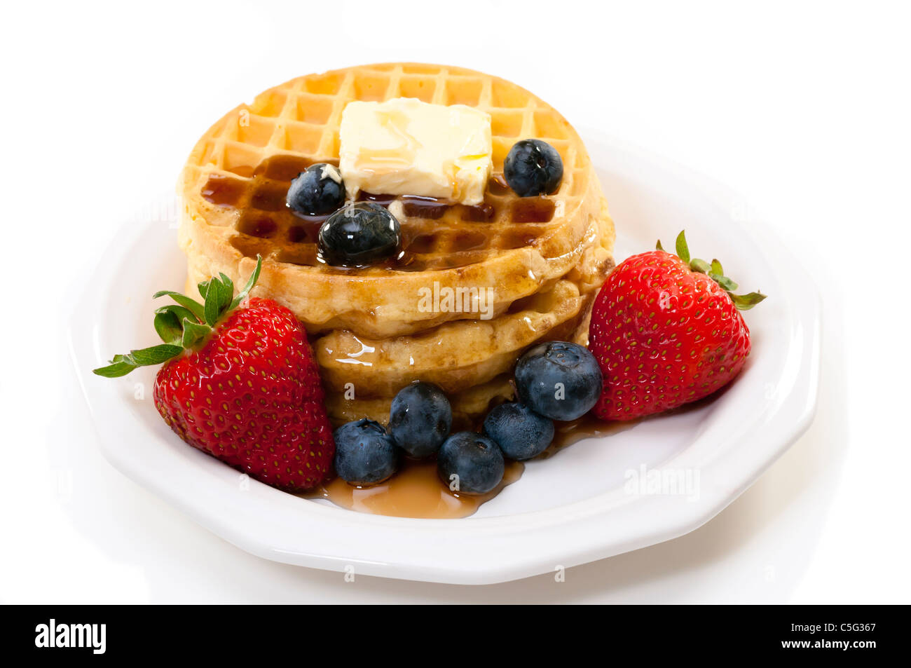 Waffles, strawberries, blueberries, and butter.   Isolated on white background. Stock Photo