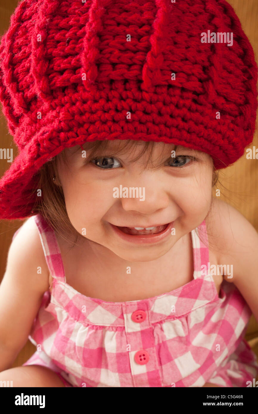 Portrait of smiling little girl wearing a red hat. Stock Photo