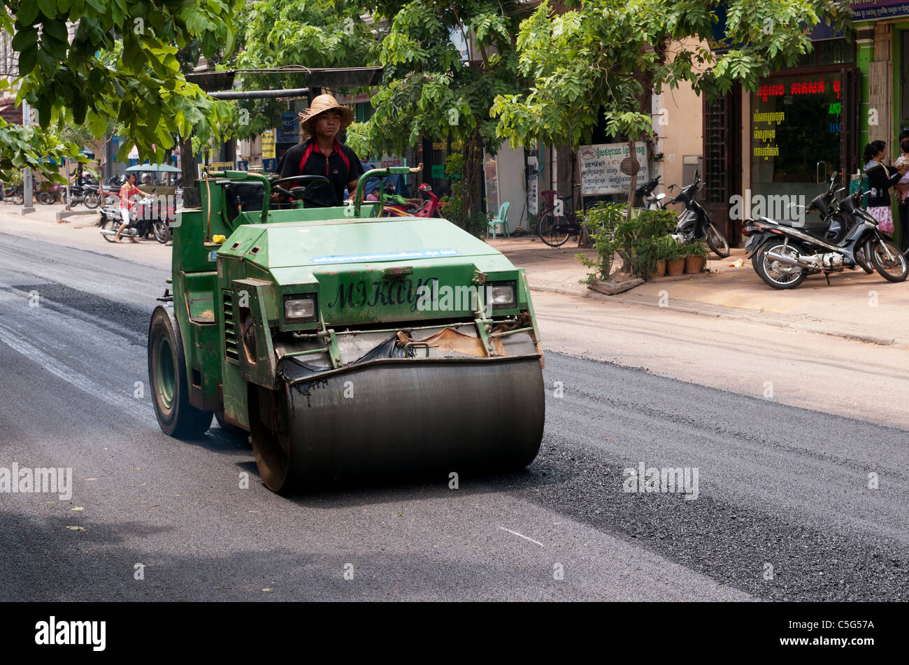Worker driving road roller over new road surface in Somdech Tep Vong St, Siem Reap, Cambodia