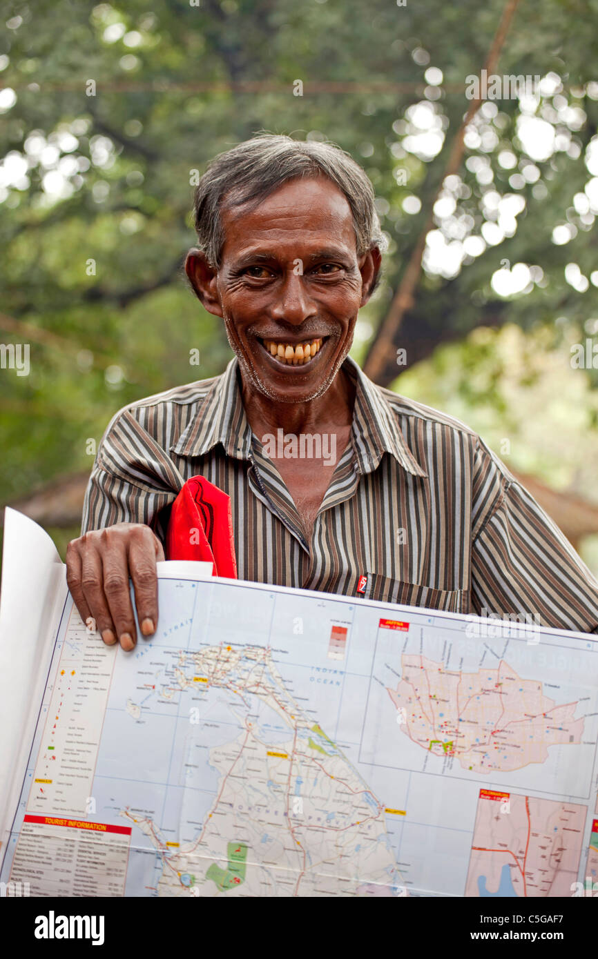 friendly salesman offering a map of Sri Lanka, Polonnaruwa, Sri Lanka, Asia Stock Photo
