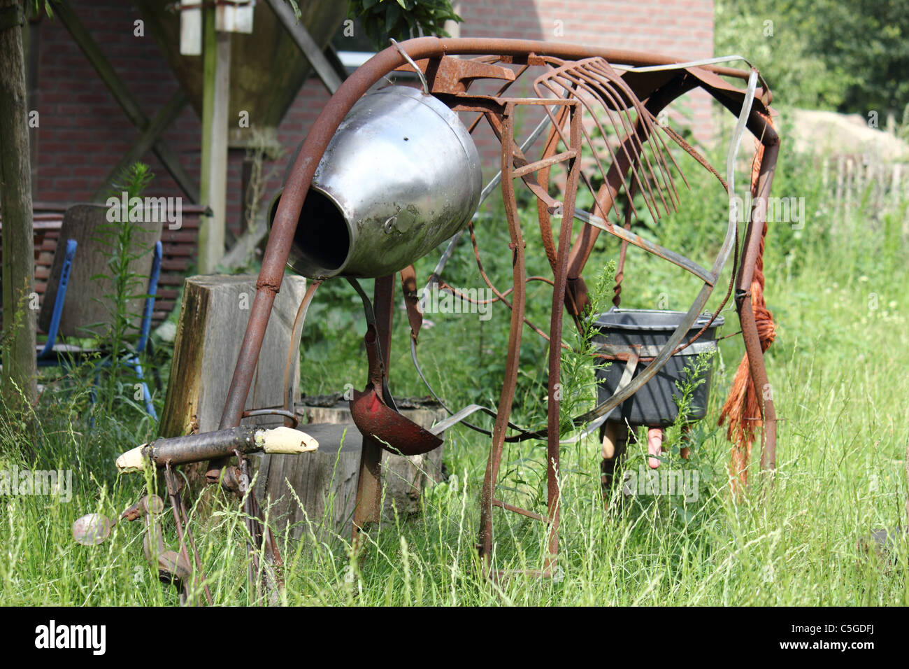 artwork of a rusty cow made from iron garden utensils , conceptual image , metaphor Stock Photo