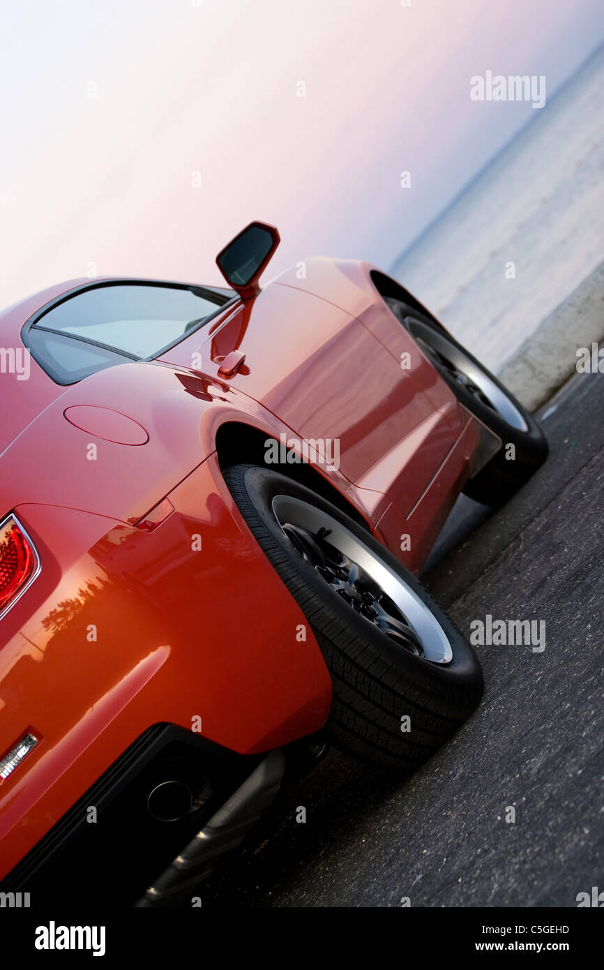 A modern sports car parked at the beach around sunset Stock Photo Alamy