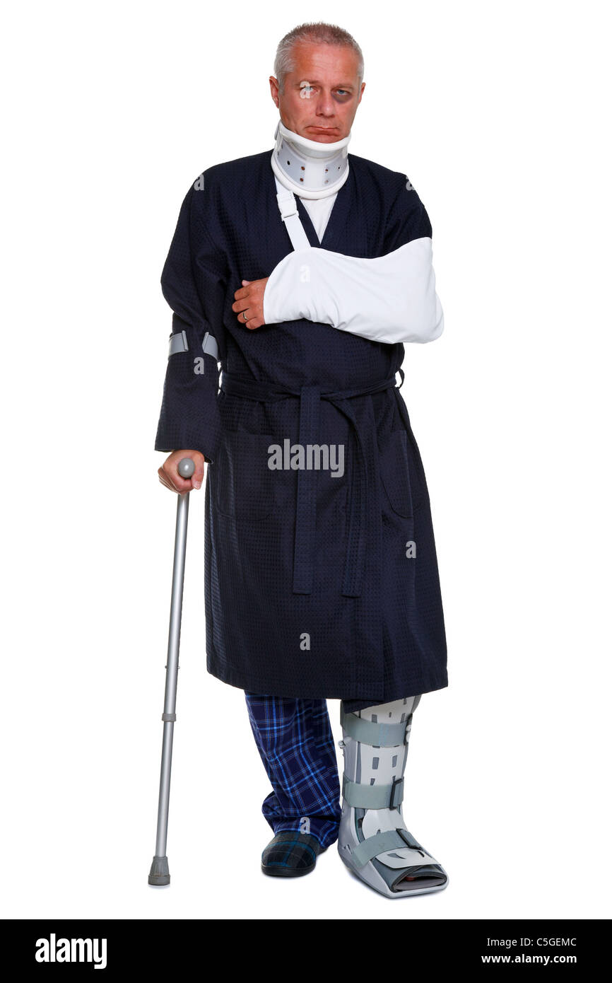 Photo of a mature male with various injuries using a crutch, he's wearing a neck brace, arm sling and leg cast Stock Photo
