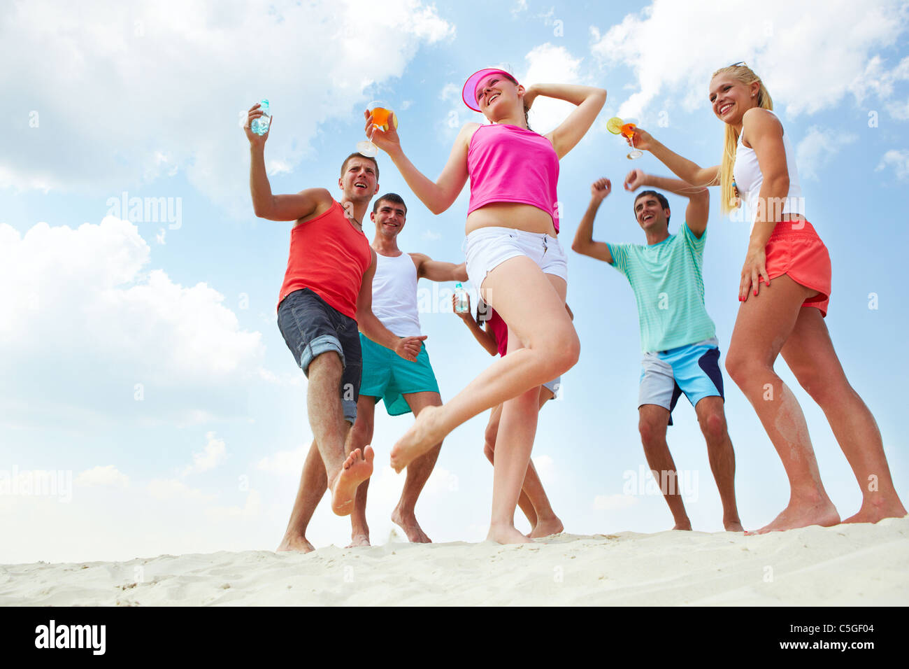 Happy friends dancing on sand hi-res stock photography and images - Alamy