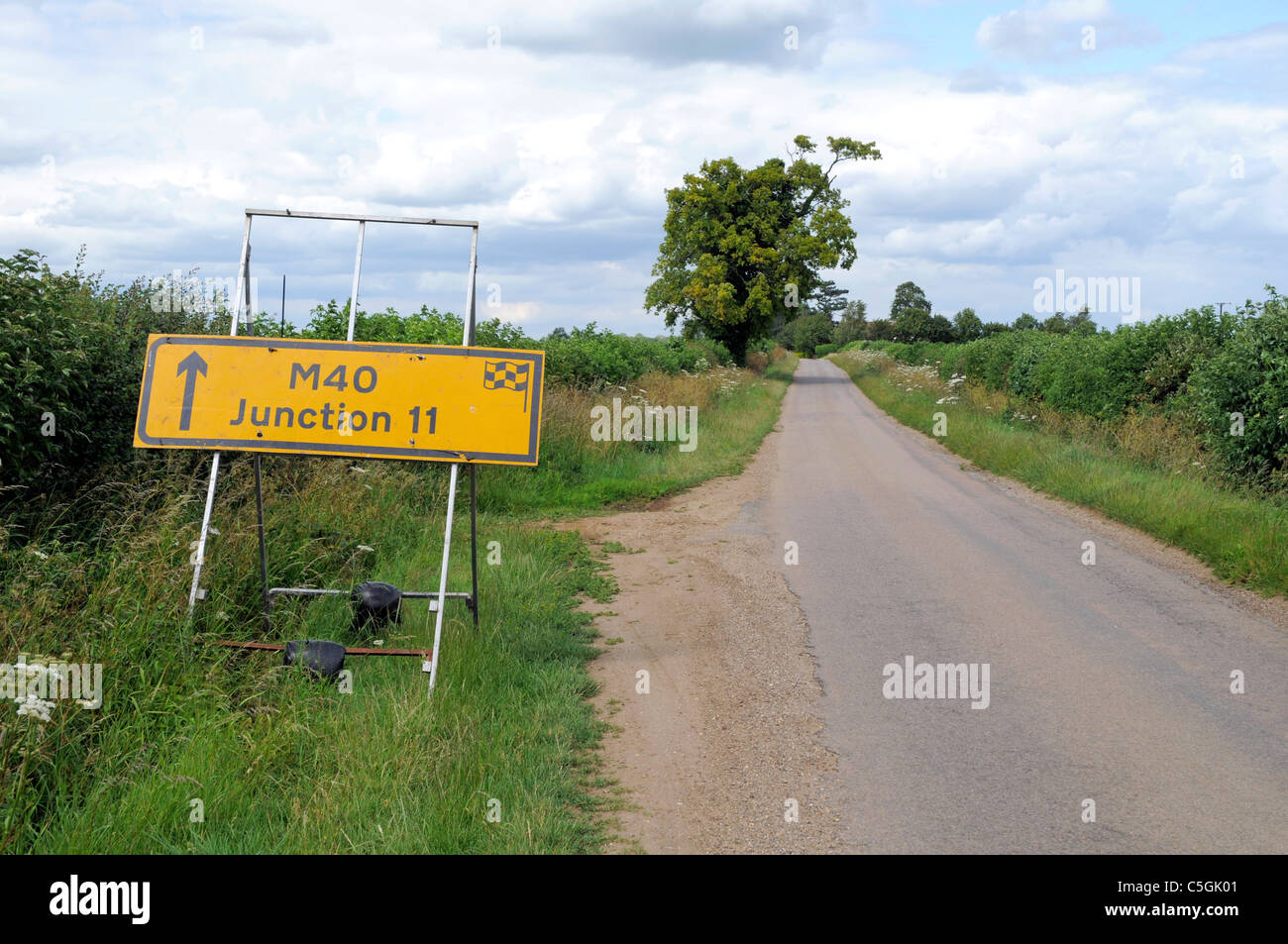 Yellow Road Sign on a Narrow Country Lane giving directions M40