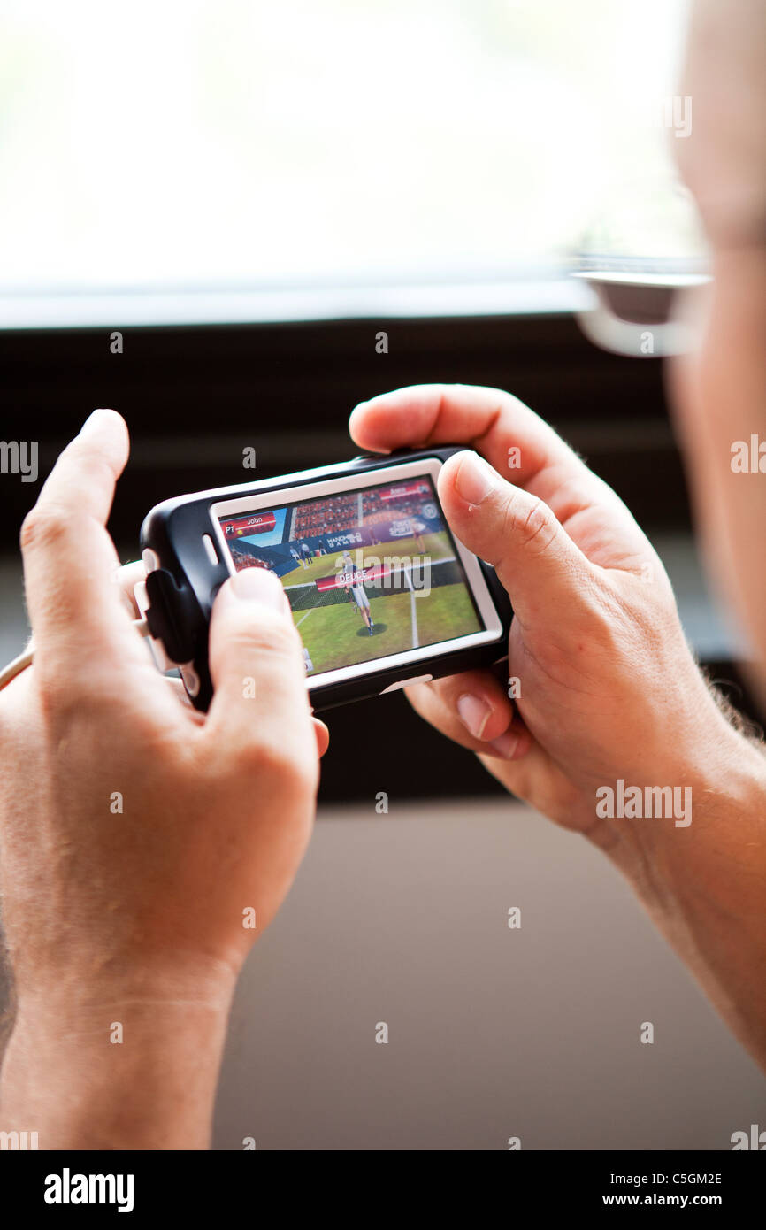 man playing game on iphone Stock Photo