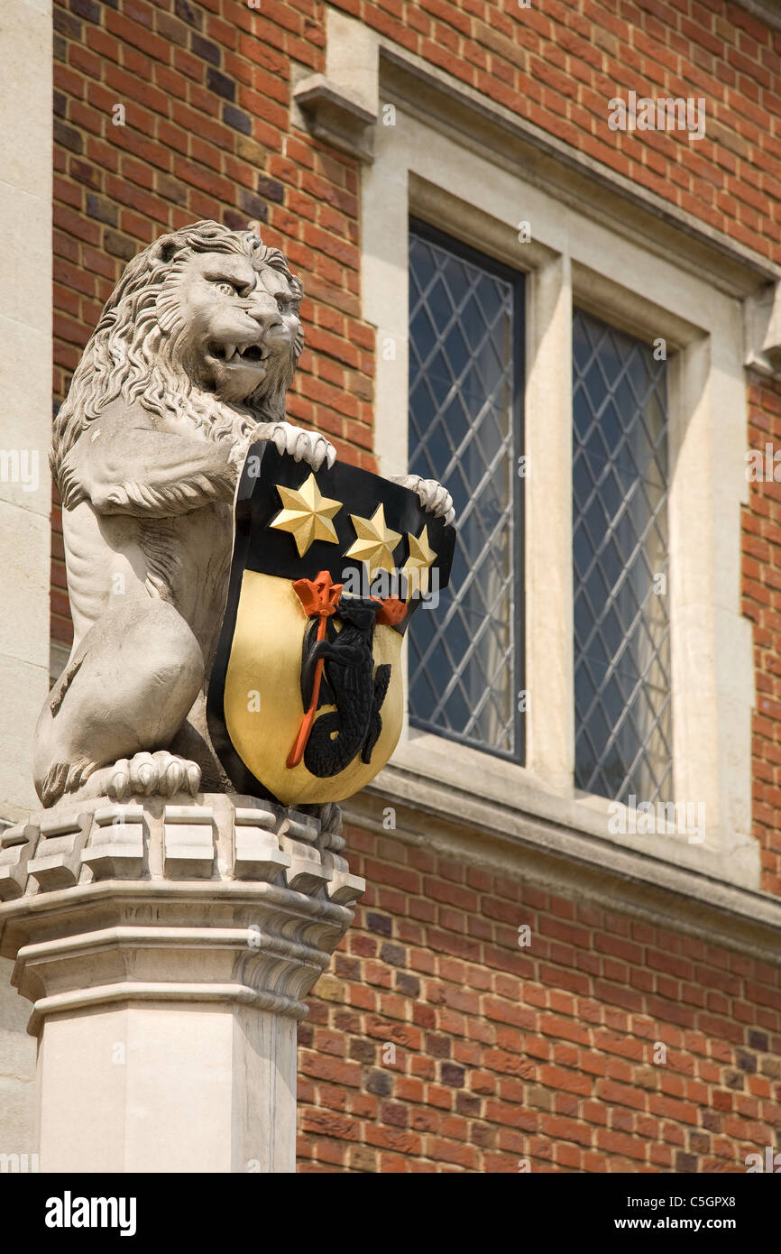 Fierce and angry looking lion guarding Crosby Hall on Cheyne Walk Chelsea London supporting an armorial shield Stock Photo