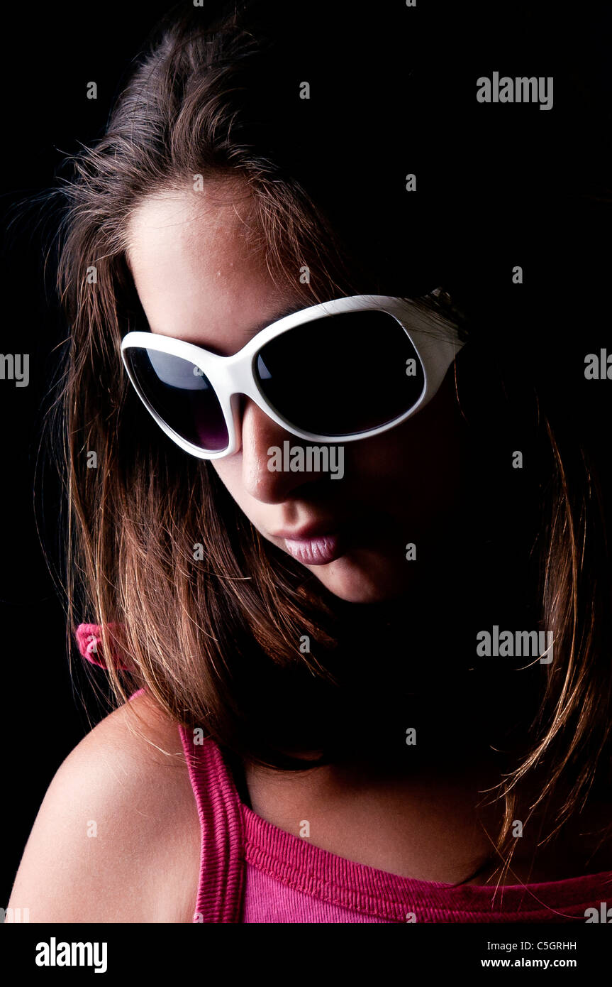 Beautiful young girl posing against a black background Stock Photo - Alamy