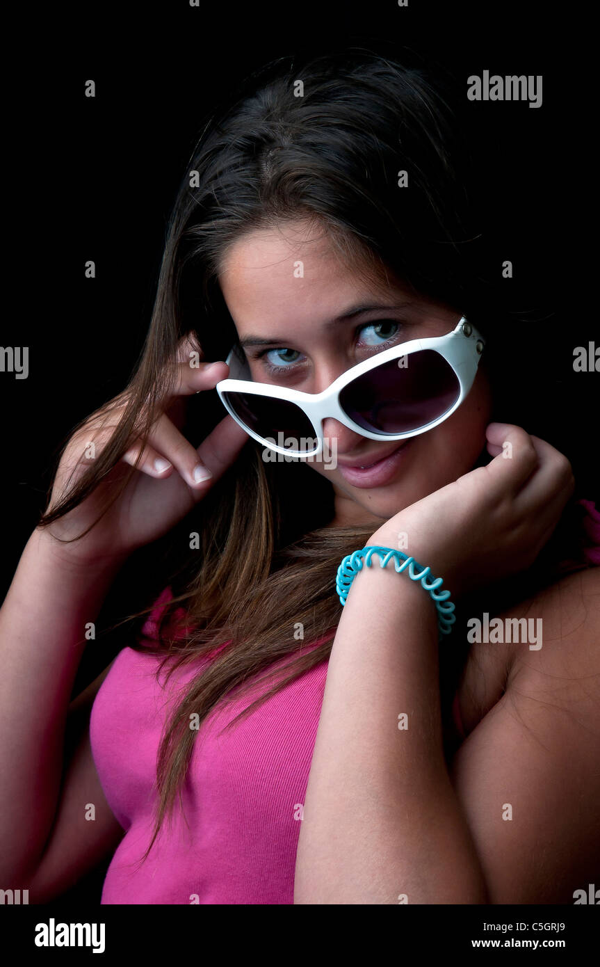 Beautiful young girl posing against a black background Stock Photo - Alamy