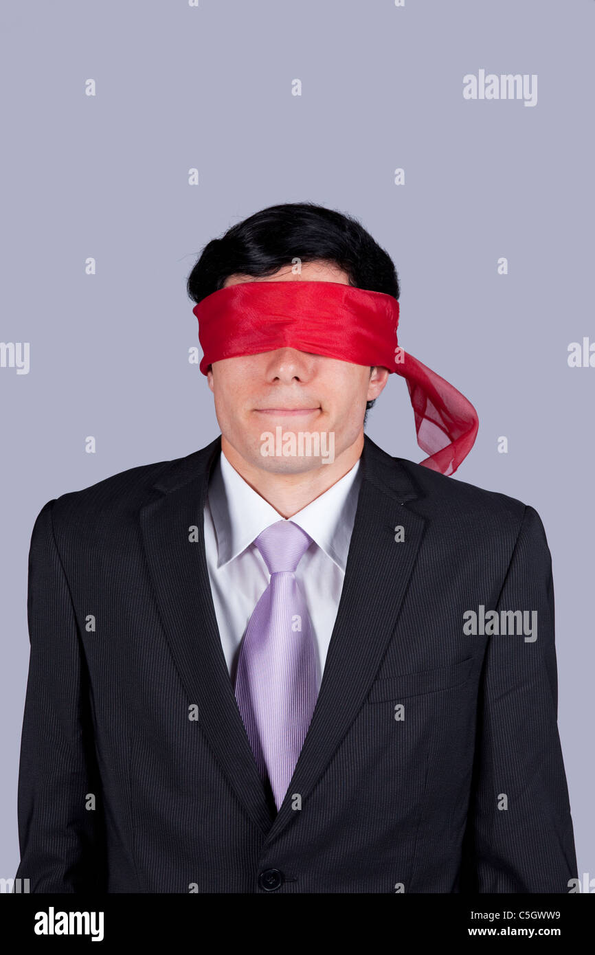 Hostage businessman with a red blindfold covering his eyes (isolated on