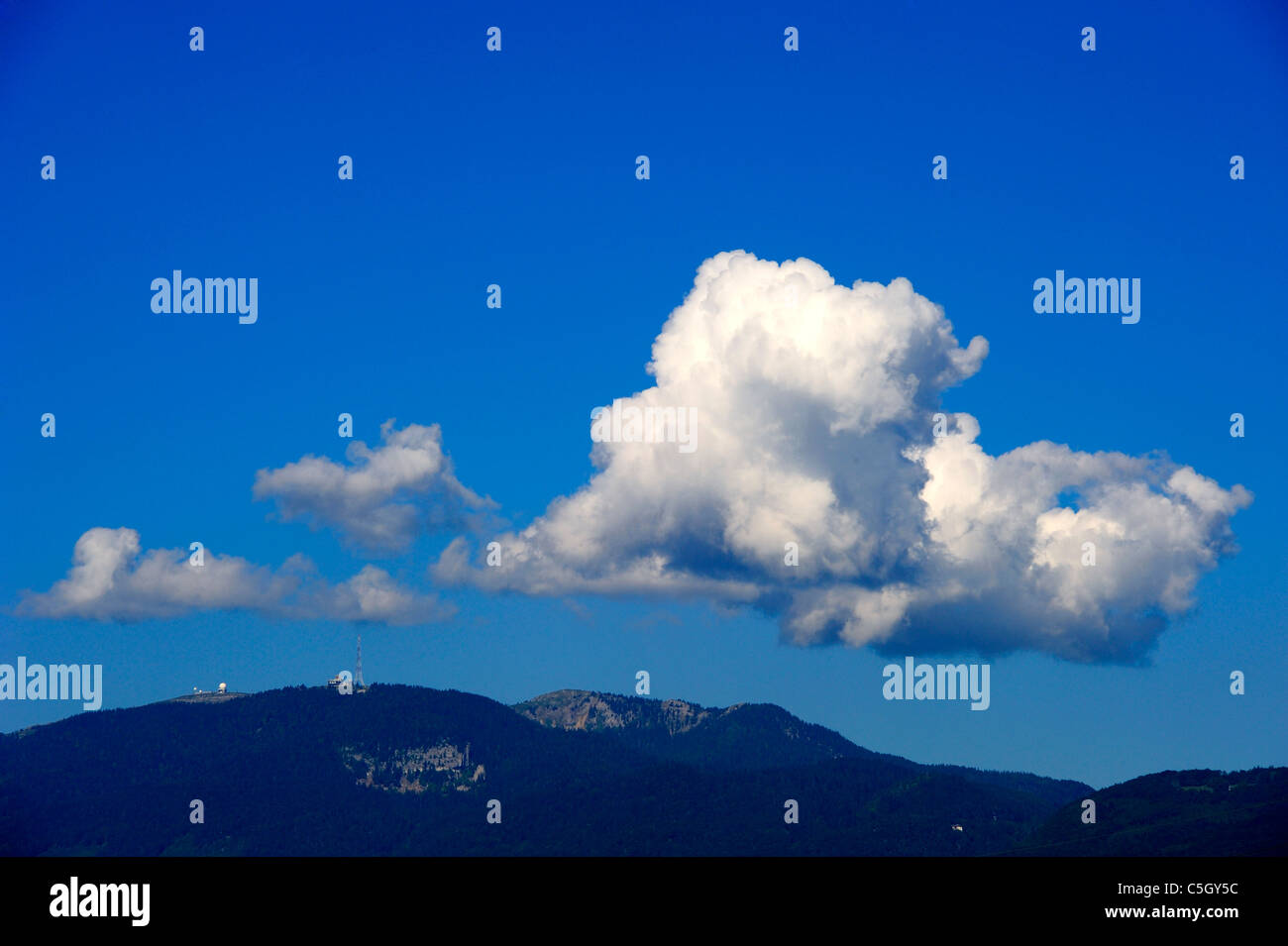 Cumulus cloud developing over the Jura mountains in Switzerland. Space for text in the sky. Stock Photo