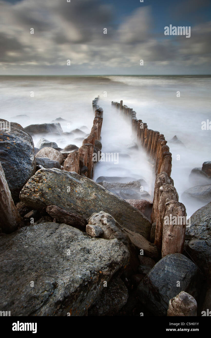 Wooden stumps and rocks forming the sea defenses at Lynton on the North Devon coast, England, United Kingdom Stock Photo