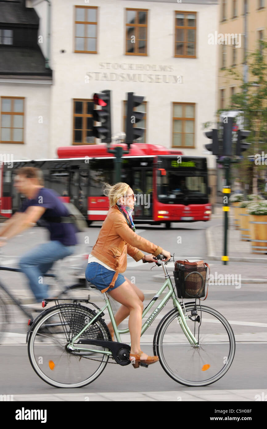 A panning shot captures cyclists and a city bus in the constant movement of the Slussen traffic interchange, Stockholm, Sweden Stock Photo