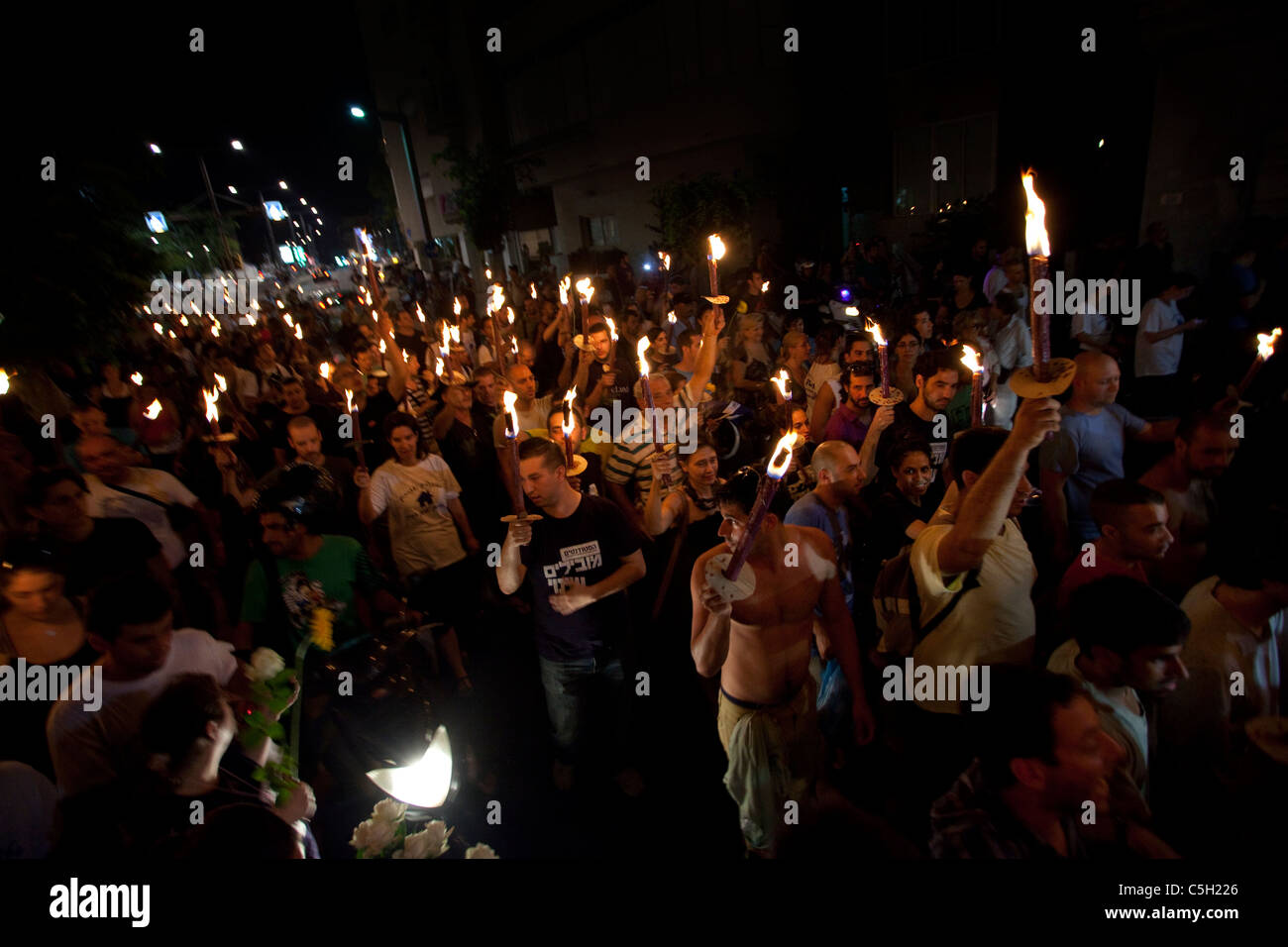 Demonstrators taking part in a torch lit march against raising housing prices in the country. downtown Tel Aviv Israel. The social justice protest also named the Tents protest were a series of demonstrations in Israel beginning in July 2011 involving hundreds of thousands of protesters from a variety of socio-economic opposing the continuing rise in the cost of living particularly housing. Stock Photo