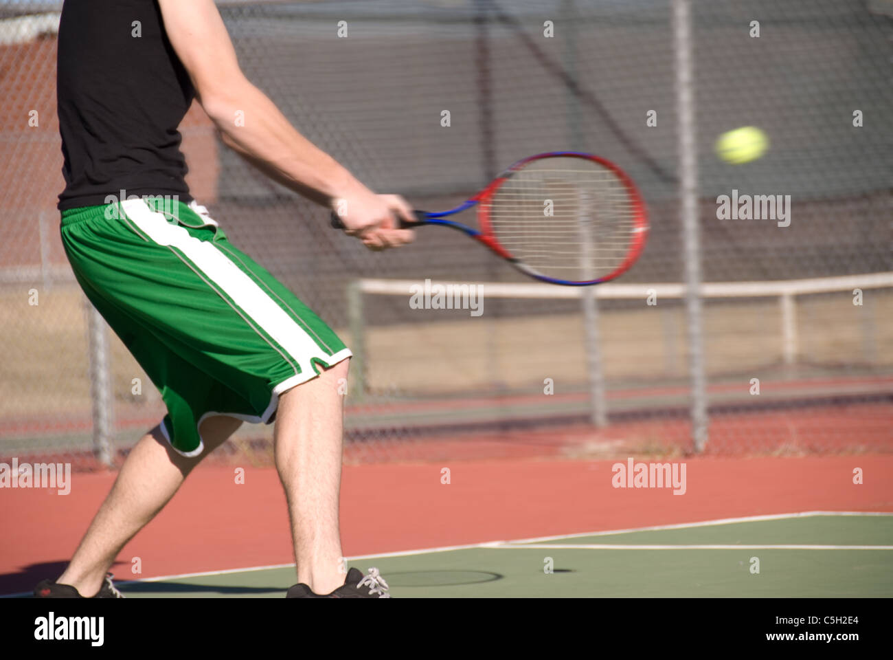 An image depicting the concept of tennis, including the court, racquets, balls and blue outdoors. Stock Photo