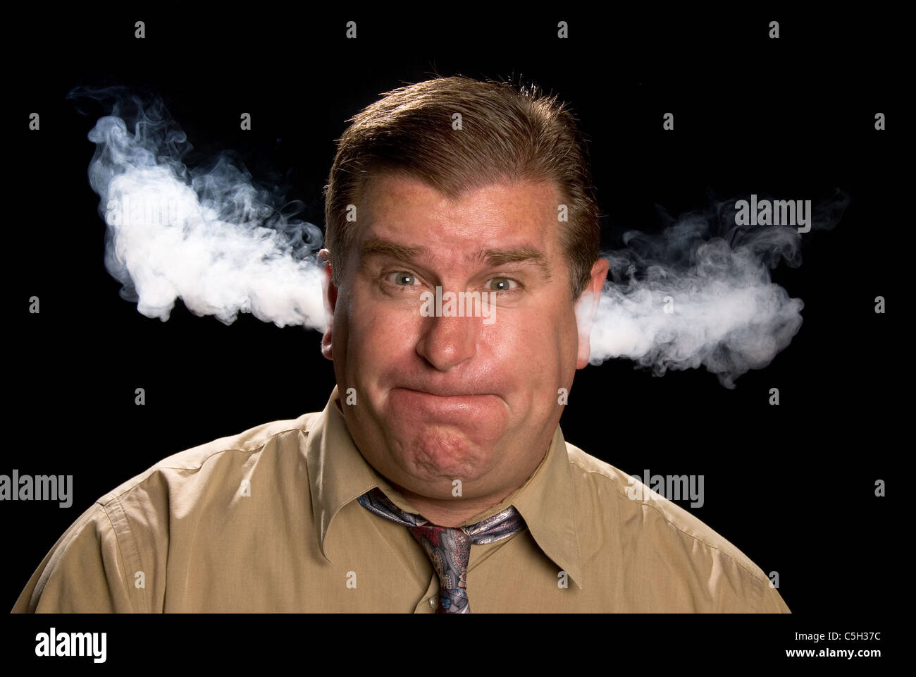 A man is angry and venting smoke from his ears in a classic expression shared in illustrations and cartoons. Stock Photo