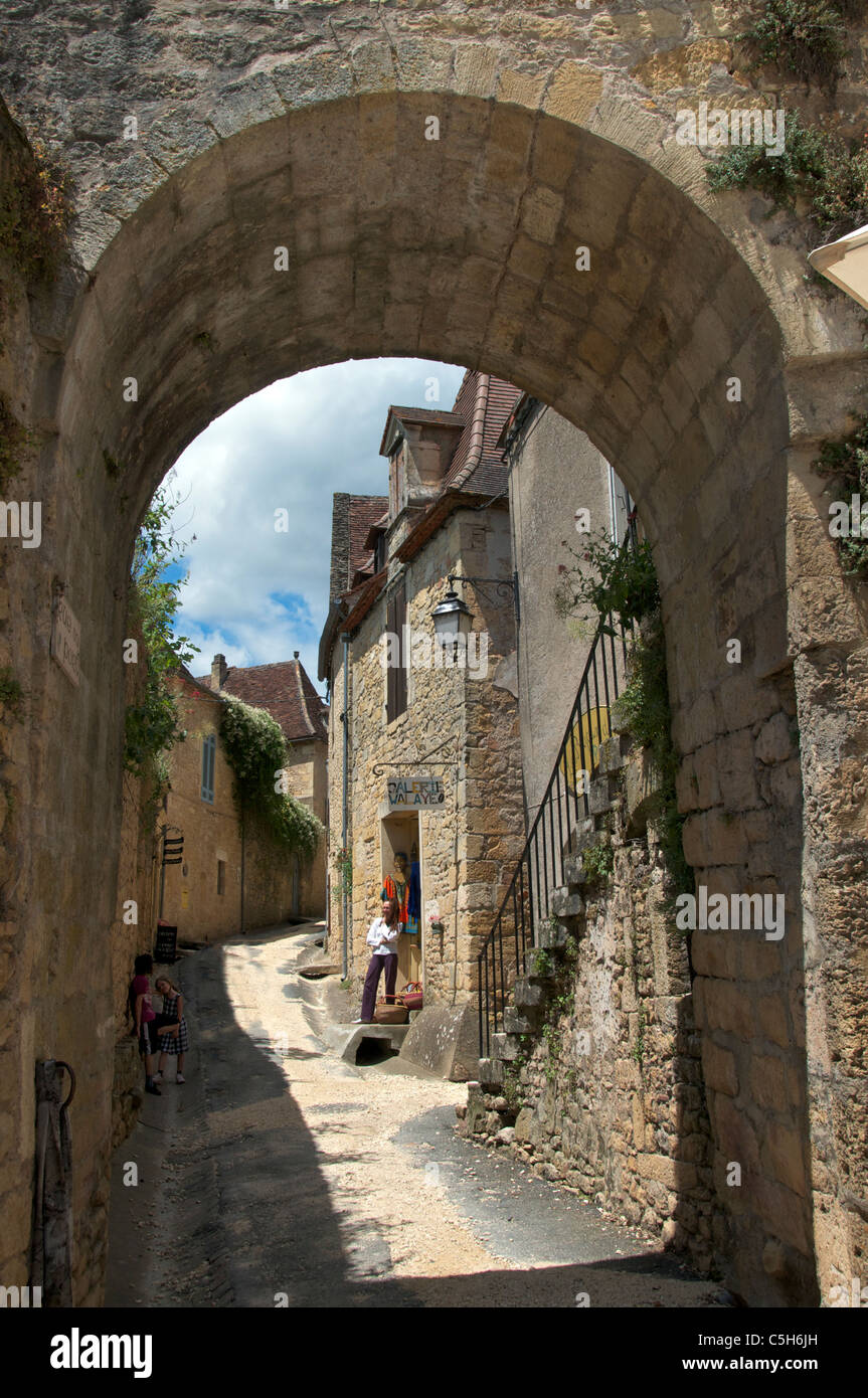 Narrow steep cobble stone lane through arch Limeuil Perigord Aquitaine France Stock Photo