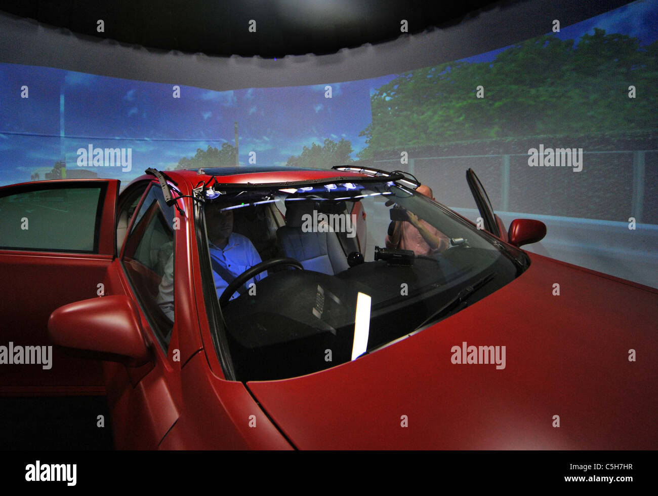 A visiting reporter sits behind the wheel of a driving simulator at Toyotas Higashi-Fuji Technical Center. Stock Photo