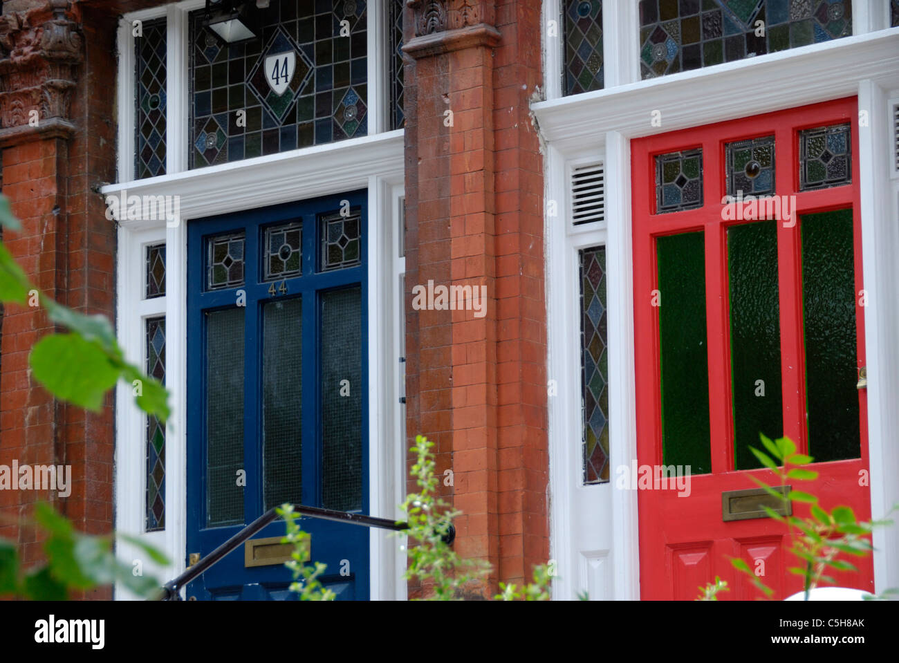 Two house front doors, one red, one blue, London, England Stock Photo