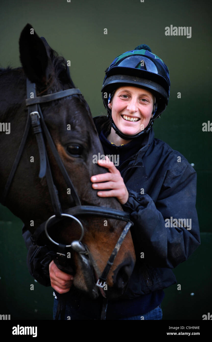 A female jockey with a racehorse at a stable in Gloucestershire UK Stock Photo