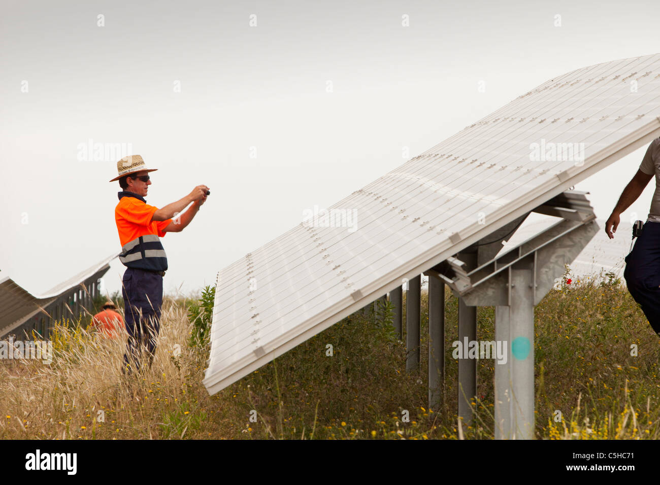 A man checking photo voltaic panels at a solar power station near Lucainena de las Torres, Andalucia, Spain. Stock Photo