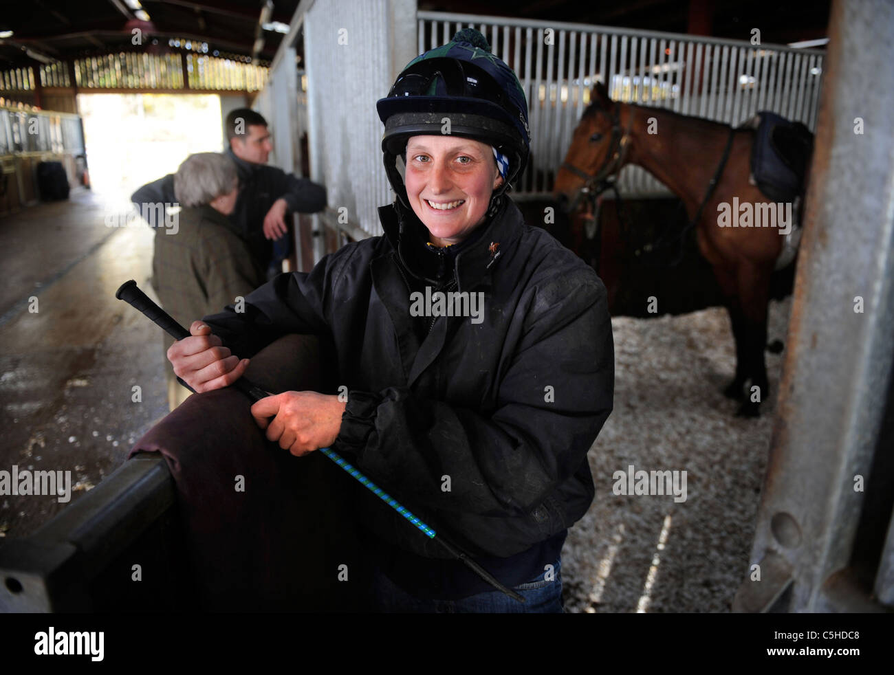 A female jockey with a racehorse at a stable in Gloucestershire UK Stock Photo