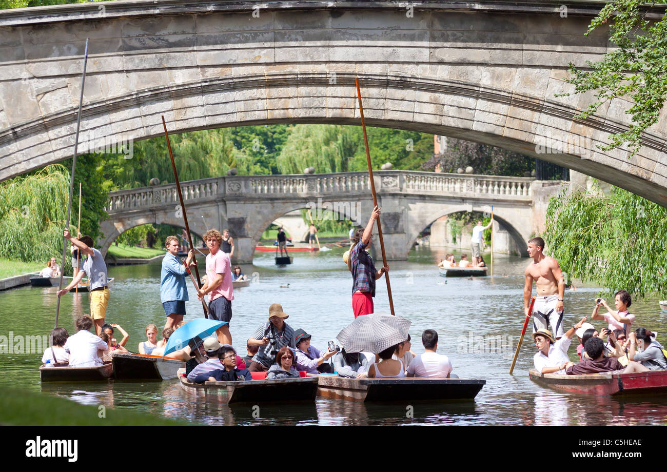 Chauffeur punts with tourists aboard on the River Cam looking through Kings College Bridge to Clare College Bridge Stock Photo