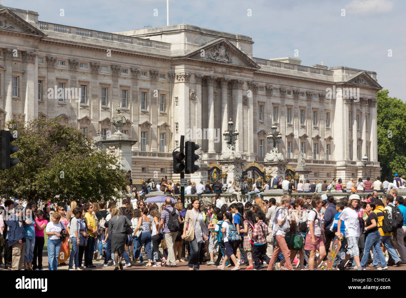 Crowds of Tourists at Buckingham Palace crossing the road just before the start of the changing of the guard ceremony Stock Photo