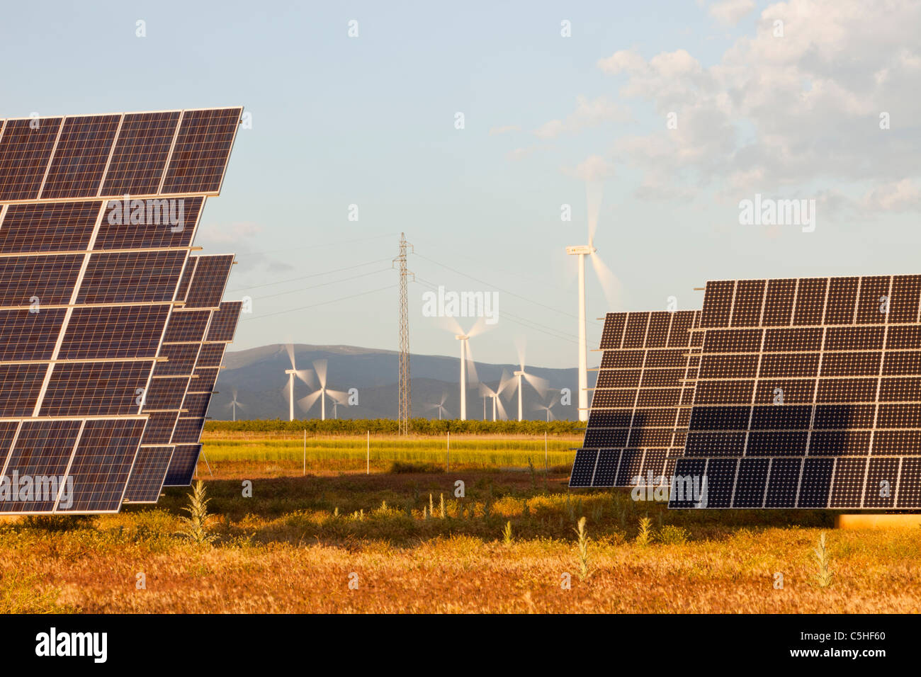 A photo voltaic solar power station near Guadix, Andalucia, Spain, with a wind farm behind. Stock Photo