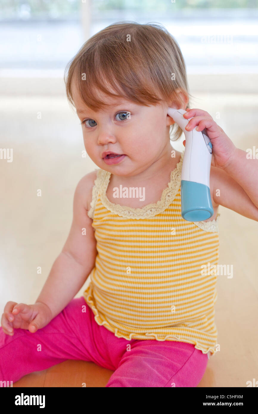 Toddler playing with thermometer Stock Photo