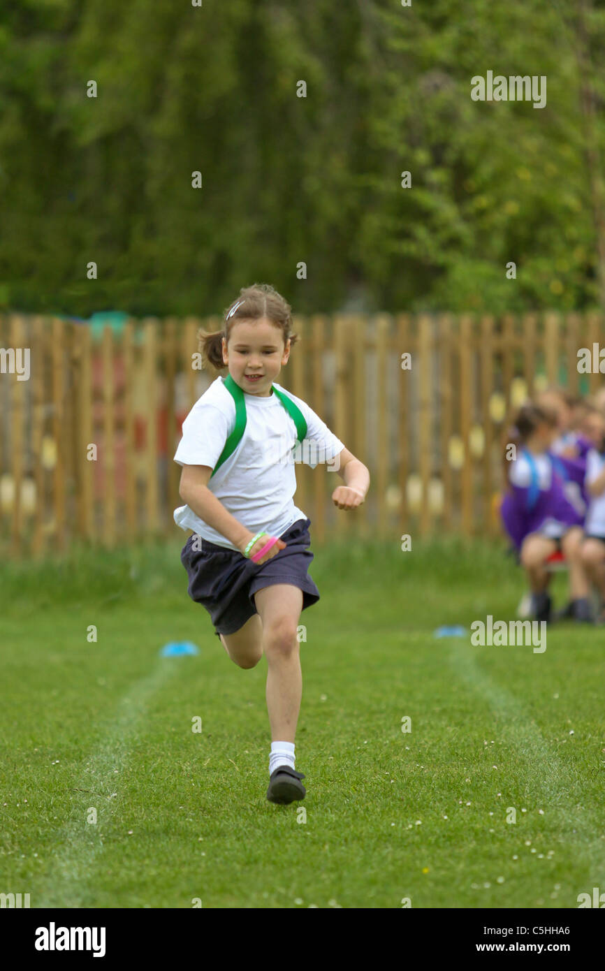 Young girl competing in running race on sportsday Stock Photo
