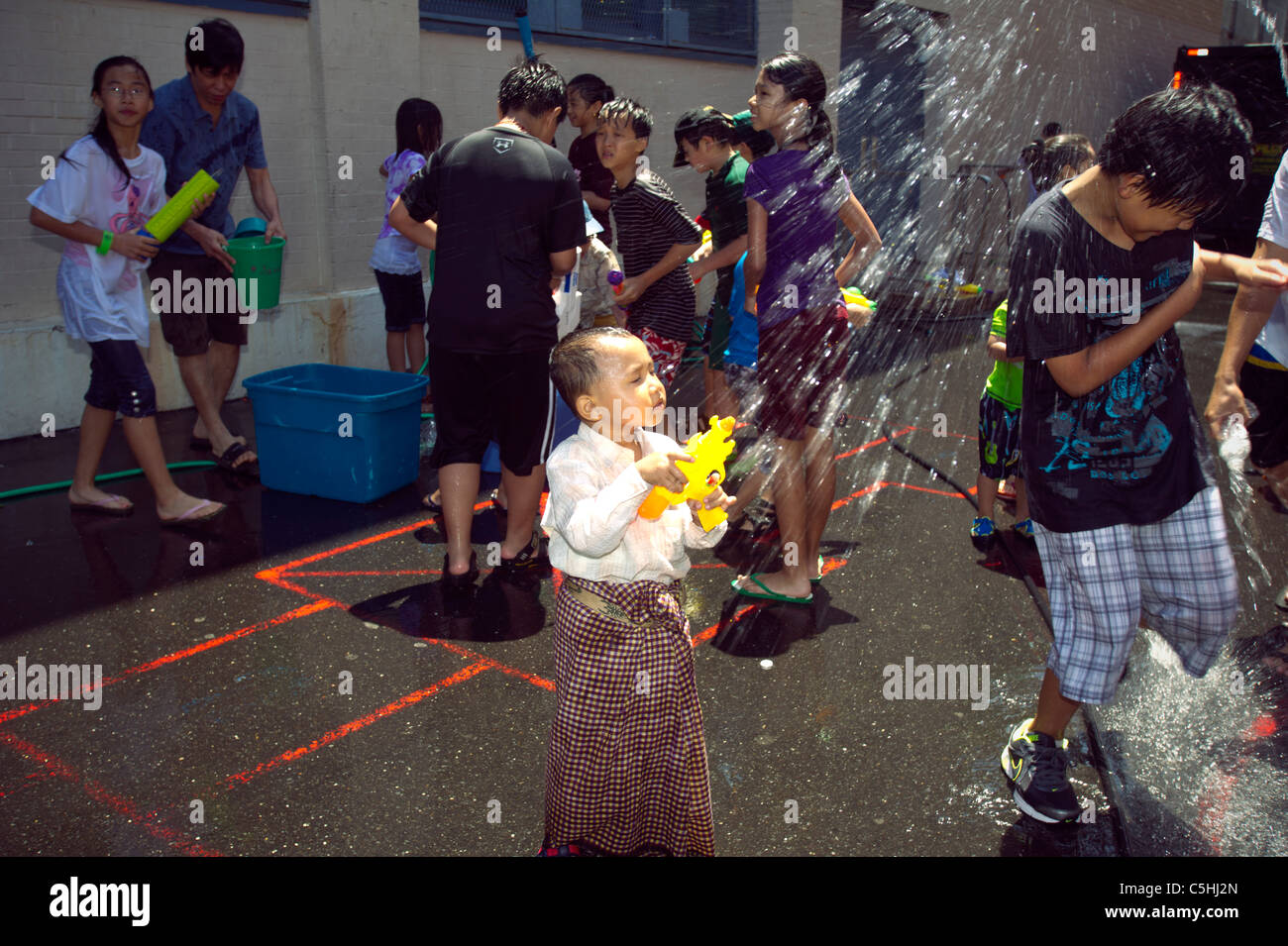 Children splash each other during the 17th annual Burmese Water Festival in New York Stock Photo