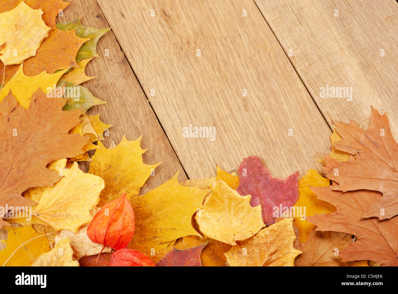 Fallen leaves on the oak planks background Stock Photo - Alamy