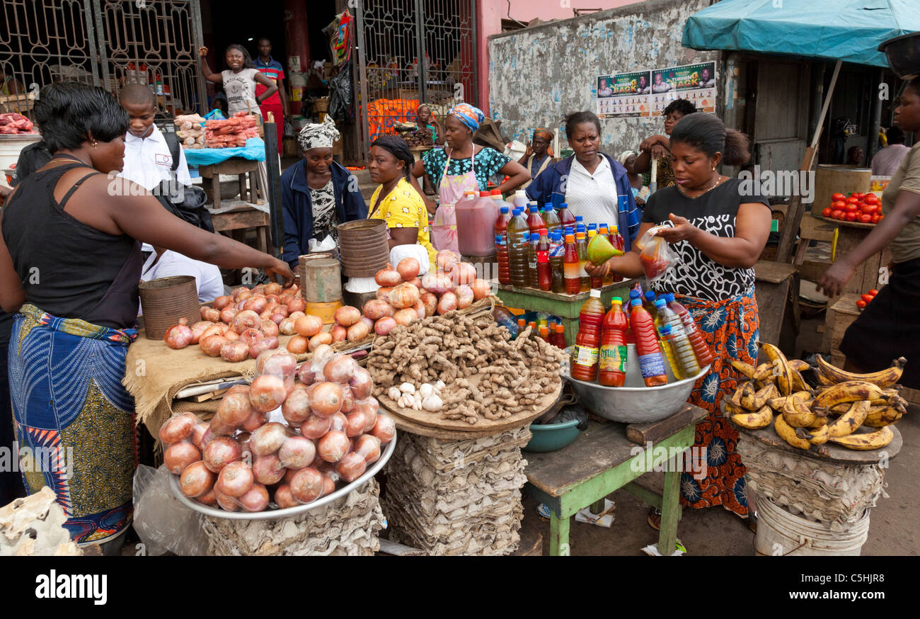 Market traders selling a range of fresh food produce and cooking Stock