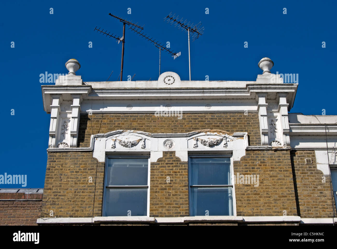 roofline architectural features below modern tv aerials on a victorian house in richmond upon thames, surrey, england Stock Photo