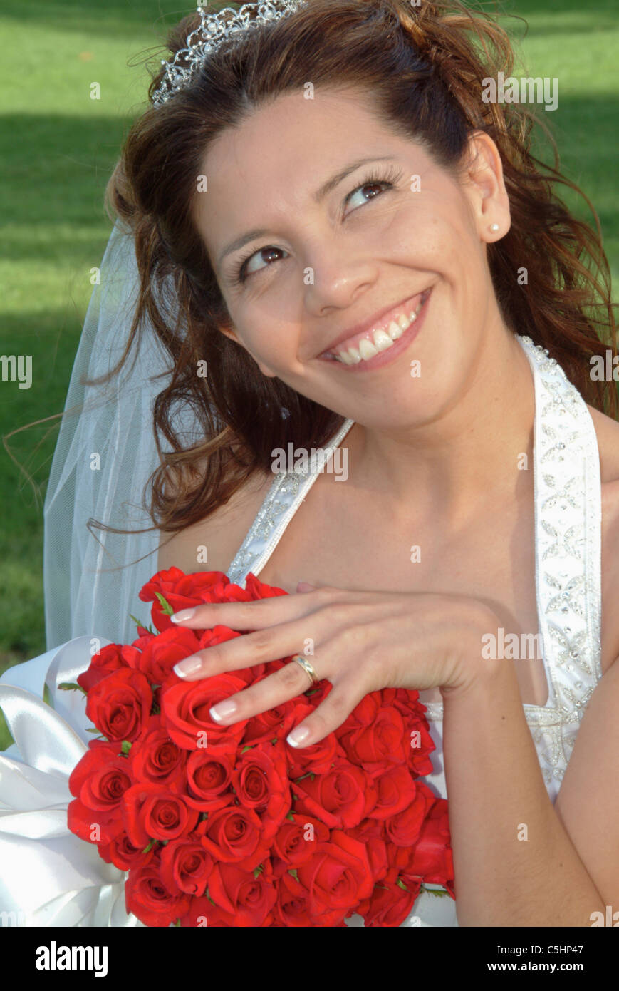 A bride shows off her wedding ring and flowers with a silly grin on her ...