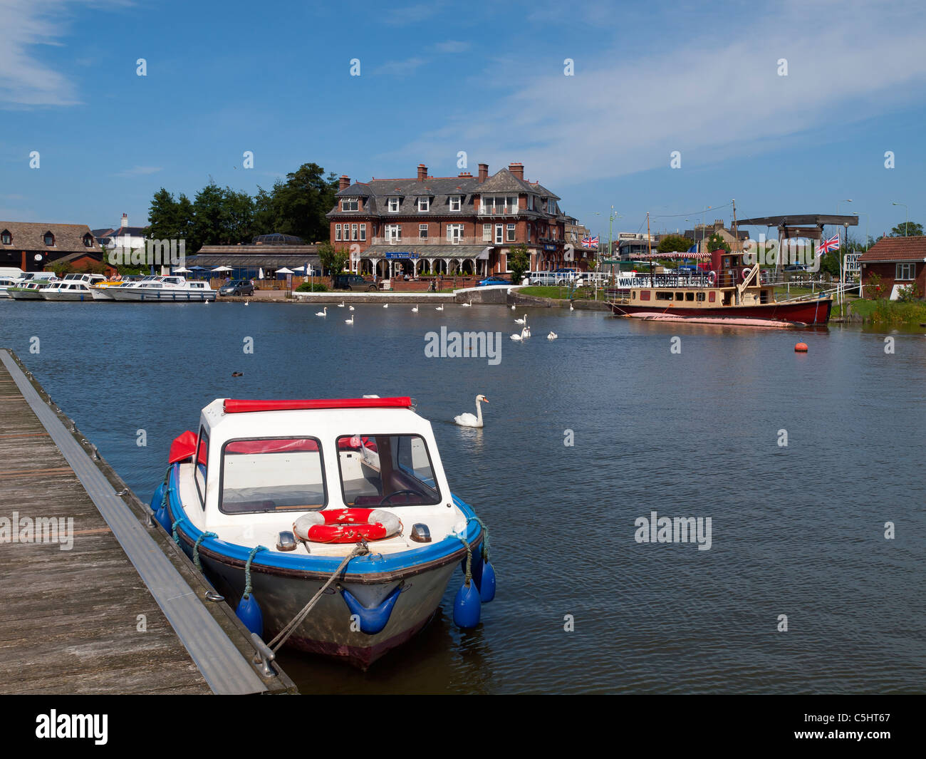 A small boat moored at a jetty opposite The Wherry Hotel at Oulton Broad Suffolk Stock Photo
