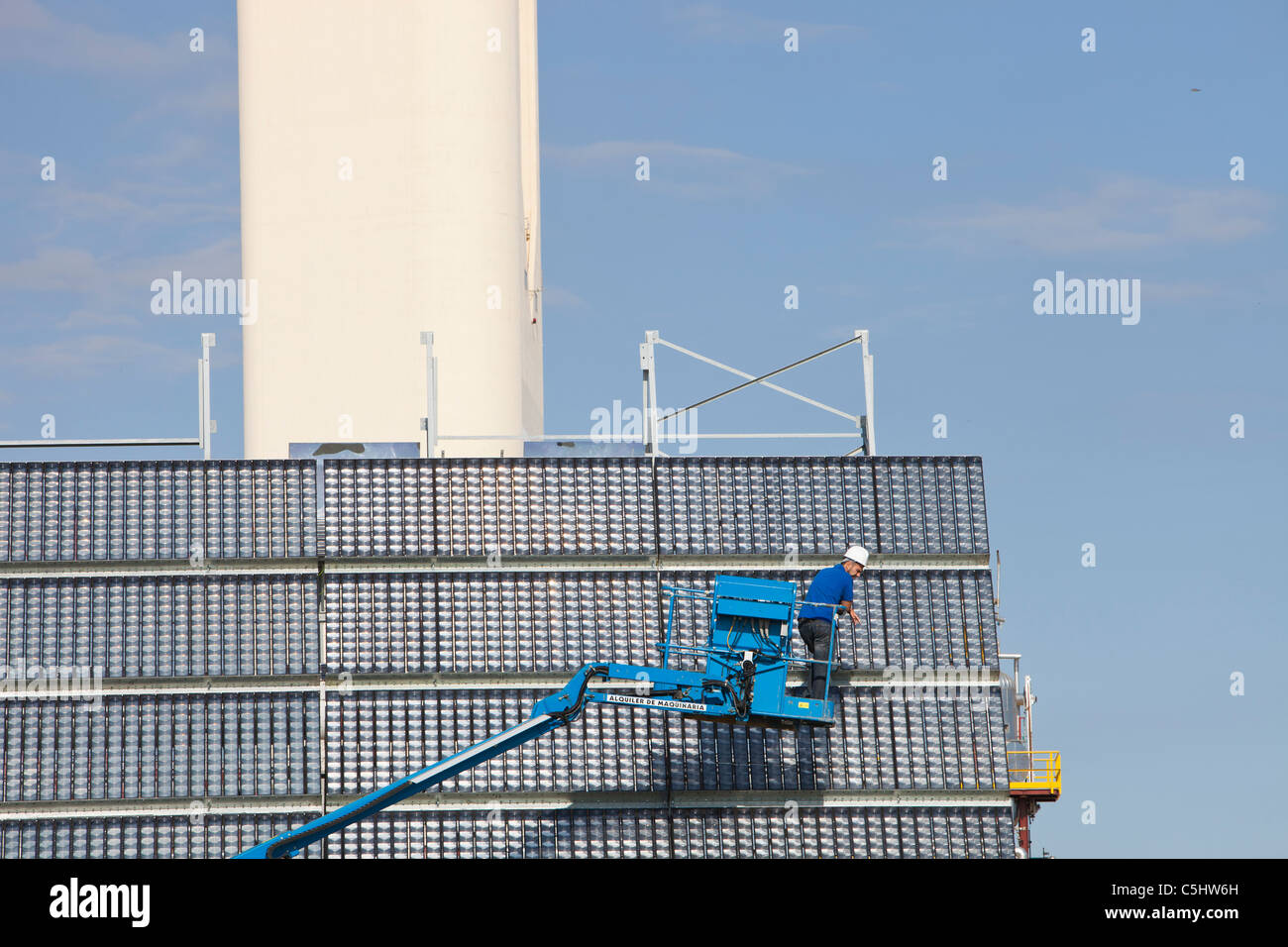 A man cleans high concentration photo voltaic panels being trialled by the research and development arm of Abengoa Solar, Stock Photo