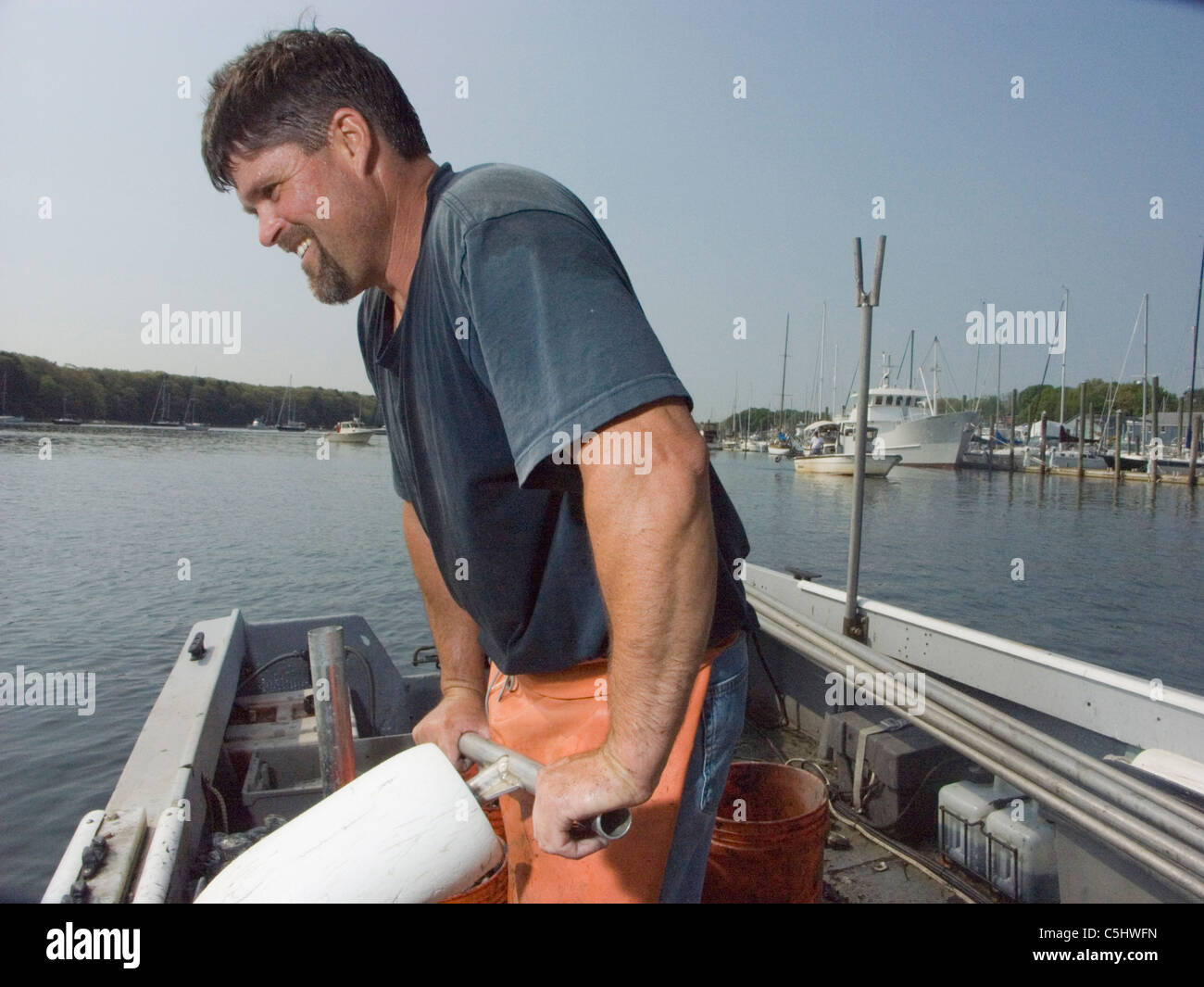 Quahoger (shellfisherman) David Middleton at work raking for clams in Narragansett Bay off Rhode Island (Model Released) Stock Photo