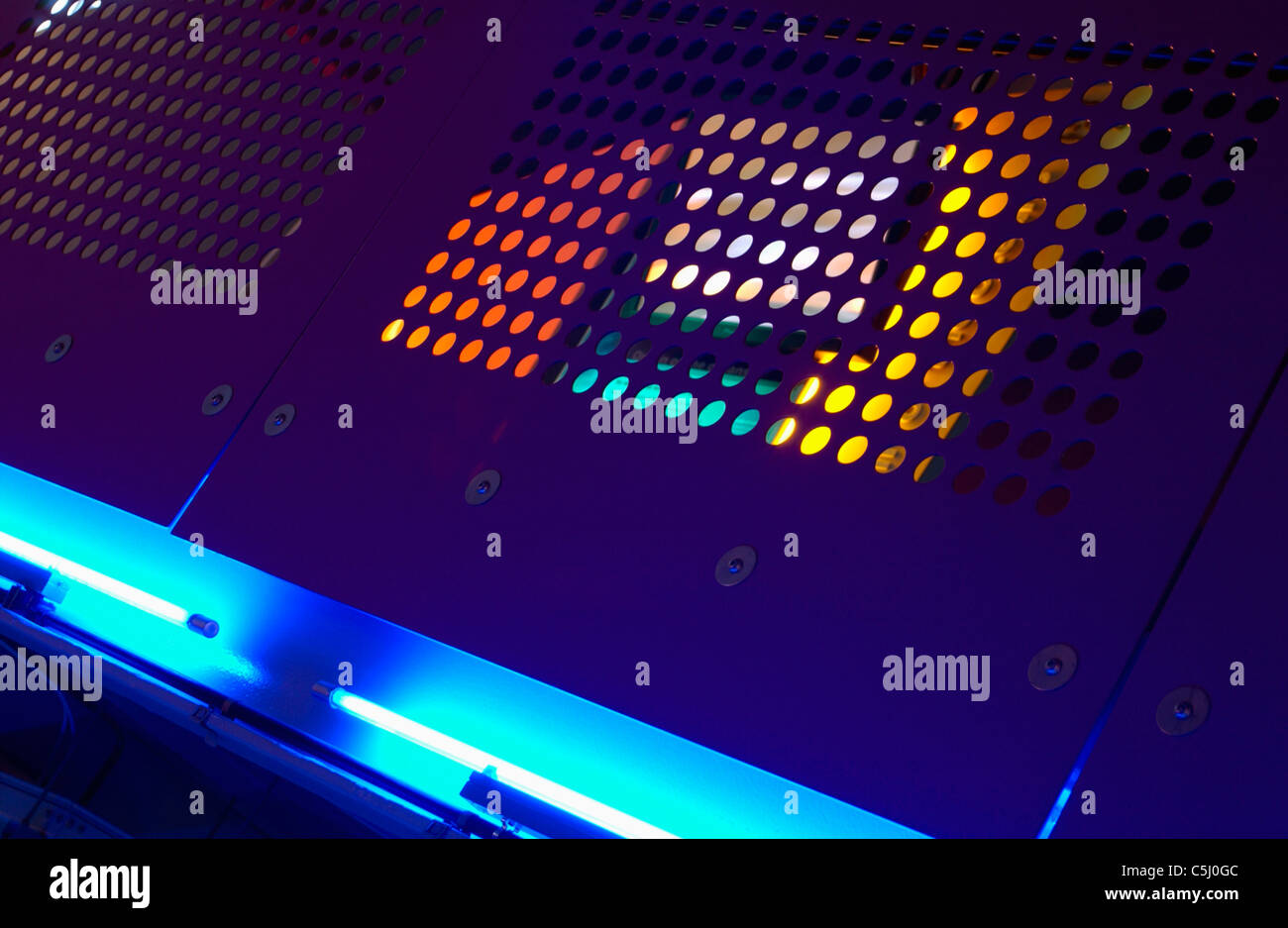 Punched metal surfaces lit with blue light. Stock Photo