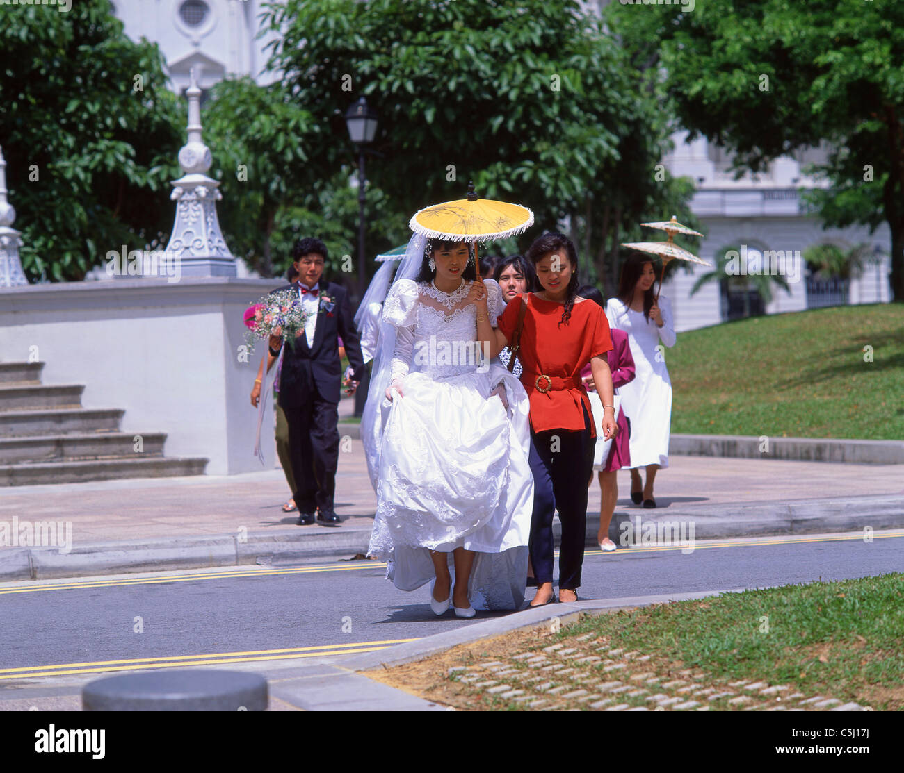 Bridal procession walking through park, Singapore Island, Republic of Singapore Stock Photo
