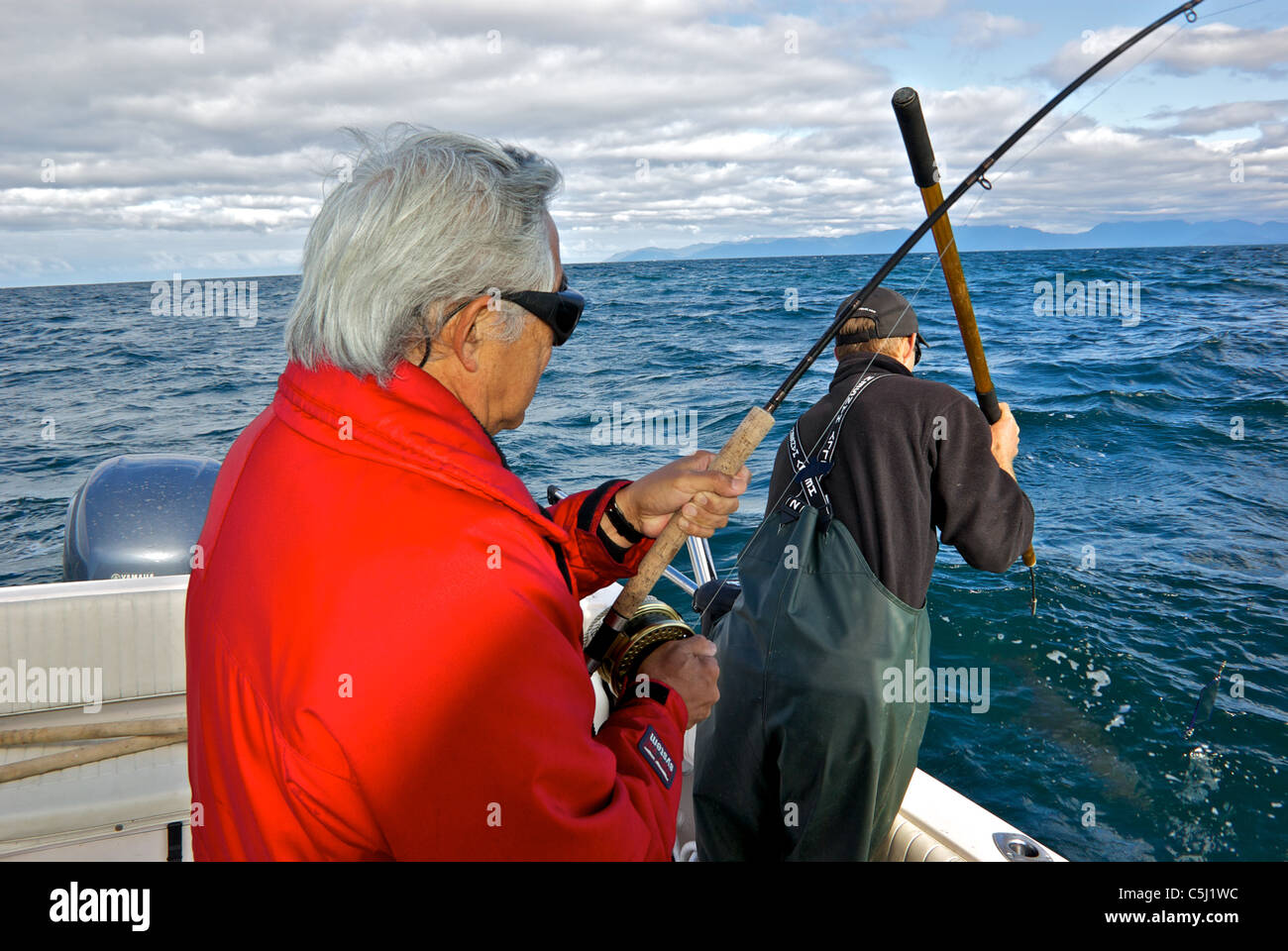Sport fishing guide ready to harpoon big halibut for charter angler guest rough seas open